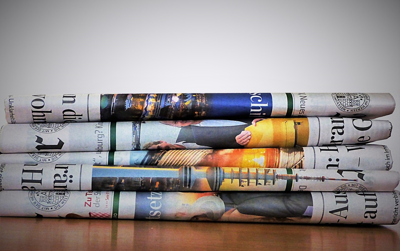 A stack of folded newspapers with colourful images.